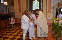 Ksiądz odbiera Dary Eucharystyczne od rodziny