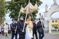 Kapłan niesie Najświętszy Sakrament pod baldachimem